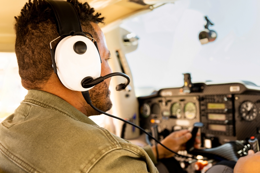 An,unrecognizable,dark Skinned,man,is,piloting,a,small,plane,while